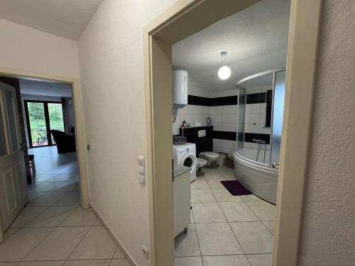 a bathroom with a tub and a toilet and a sink at Apartmani Natura in Sanski most
