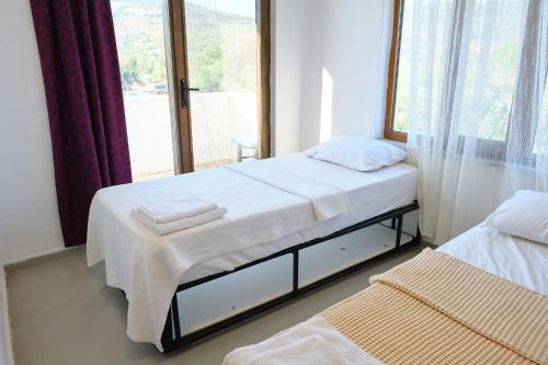 a bedroom with two beds and a window at Ekin Assos in Sokakagzi