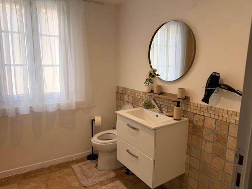 a bathroom with a white toilet and a mirror at Le petit nid provençal in Sorgues