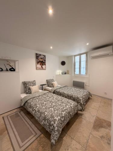 a bedroom with two beds and a couch at Le petit nid provençal in Sorgues