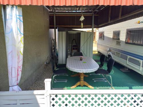 a table and chairs on a porch with an rv at Ferienwohnwagen Rudolf in Coswig