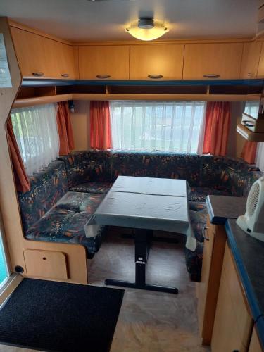 a living room with a table and a couch in a caravan at Ferienwohnwagen Rudolf in Coswig