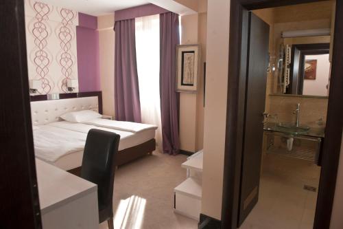 a hotel room with a bed and a sink at Hotel Crnogorska Kuća in Podgorica