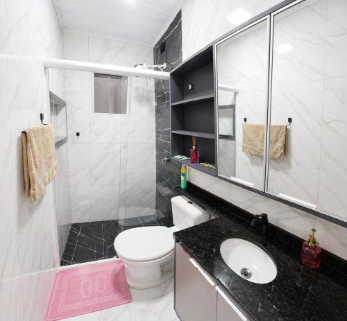 a bathroom with a toilet and a sink and a shower at Casa J&G in Fazenda Rio Grande