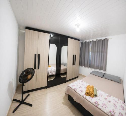 a bedroom with a bed and a chair in it at Casa J&G in Fazenda Rio Grande
