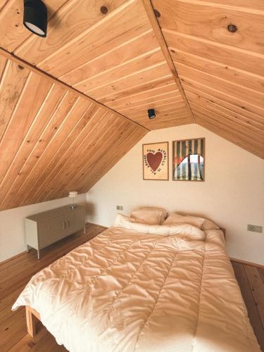 a large bed in a room with a wooden ceiling at Ostoja Janowice in Janowice