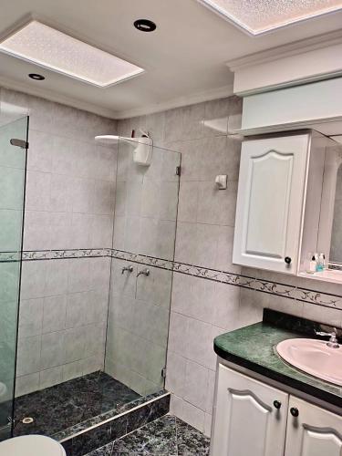 a bathroom with a shower and a sink at Casa cerca al Campín in Bogotá