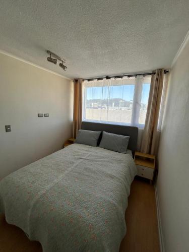 a bedroom with a bed and a large window at Departamento Centro Concepción in Concepción