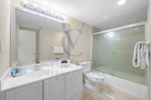 a bathroom with a toilet and a sink and a mirror at Ocean Reserve Miami Sunny Isles Collins Ave in Sunny Isles Beach