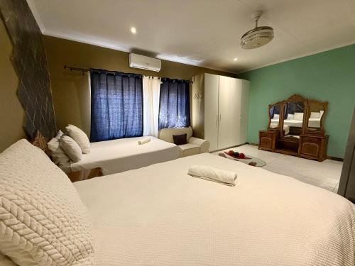 a hotel room with two beds and a living room at Blue Lantern Bed and Breakfast in Kempton Park