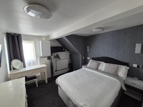 a bedroom with a large white bed and a bathroom at Ground floor 1 bed flat in Weymouth