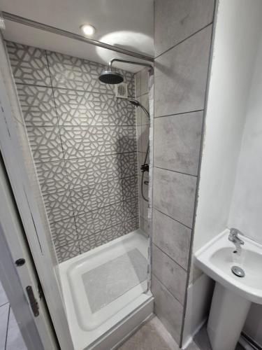 a shower with a glass door next to a sink at Ground floor 1 bed flat in Weymouth