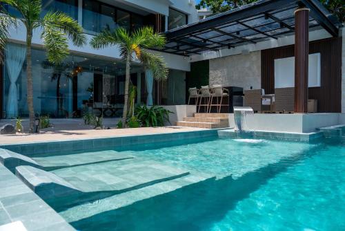 a swimming pool in front of a building at Villa Magdalena - 7BR - Oceanfront with Heated Pool in Cancún
