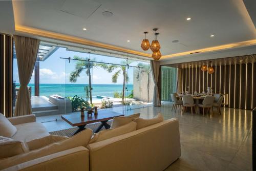 a living room with a couch and a table at Villa Magdalena - 7BR - Oceanfront with Heated Pool in Cancún