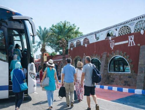 a group of people getting on a bus at Tuya Abu Simbel Hotel in Abu Simbel