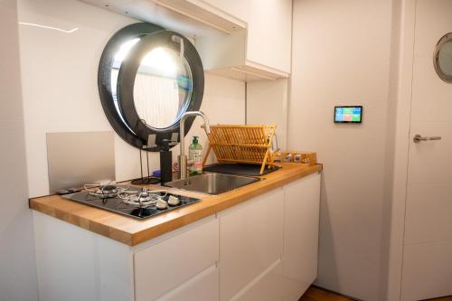 a small kitchen with a sink and a mirror at Selene Houseboat Polańczyk in Polańczyk