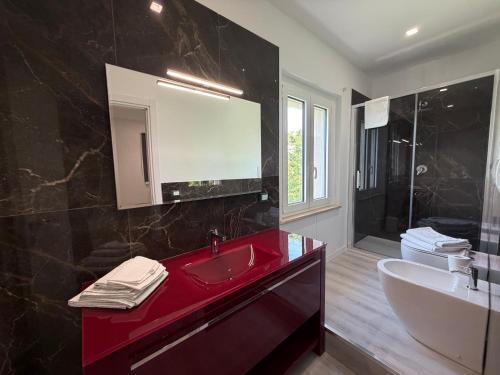 a bathroom with a red sink and a mirror at VILLA NATURA in Corropoli