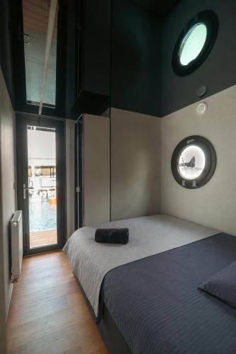 a bedroom with a bed and a round window at Selene Houseboat Polańczyk in Polańczyk
