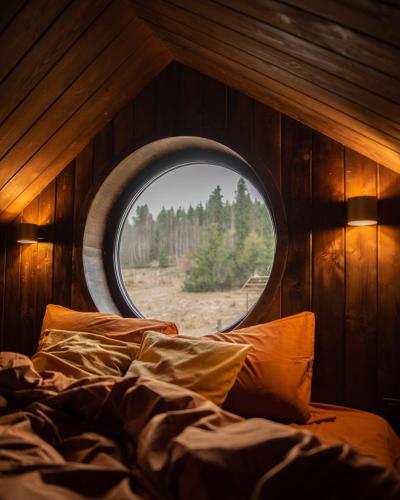 a bed in a room with a round window at Silence cabin in Myta
