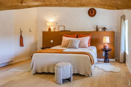 a bedroom with a large bed and a brick wall at Chambre d'hôtes "Ô berges de Brens" in Brens