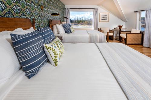 a large bedroom with two beds and a window at Breakwater Inn in Kennebunkport
