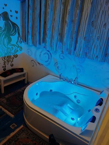 a bathroom with a bath tub with a painting on the wall at Suite Capurso Bari jacuzzi e parking in Capurso
