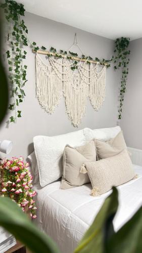 a bedroom with a white bed with plants on the wall at Tropical Casita LaVida in Tampa