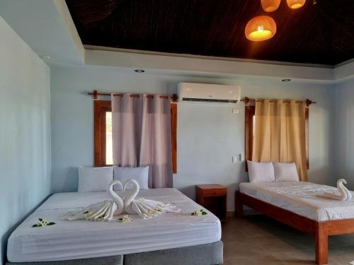 a bedroom with two beds with towels on them at Rancho Primavera in Cuatro Esquinas