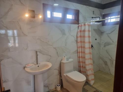a bathroom with a toilet and a sink at Rancho Primavera in Cuatro Esquinas