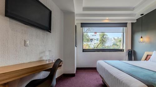 a hotel room with a bed and a window at Uniko Living Roma in Mexico City