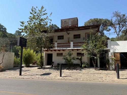 a building on the side of the road with a sign in front at Encino House Hotel & Glamping Valle de Bravo in Valle de Bravo