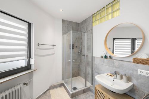 a bathroom with a shower and a sink and a mirror at Stay COZY - The Lounge- Kingsize - Terrasse - Beste Lage in Aschaffenburg