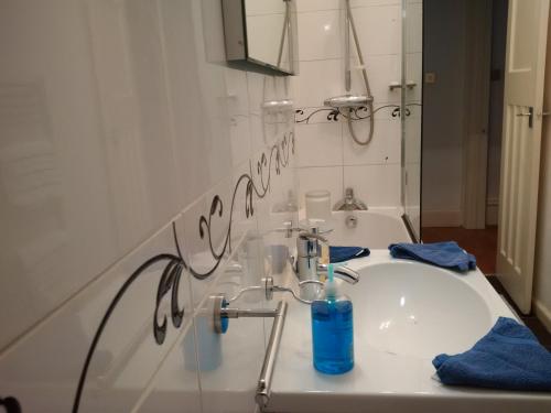 a bathroom with a sink with a blue bottle on it at Exceptional guest rated 1 bedroom Kensington apartment with Super Wifi in London