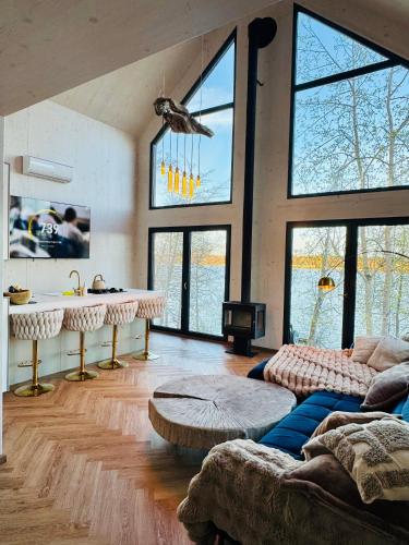 a living room with large windows and a couch at Cëchô Woda in Parchowo