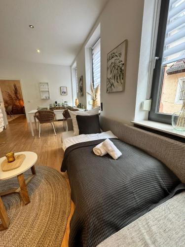 a living room with two beds and a table at Stay COZY - The Lounge- Kingsize - Terrasse - Beste Lage in Aschaffenburg