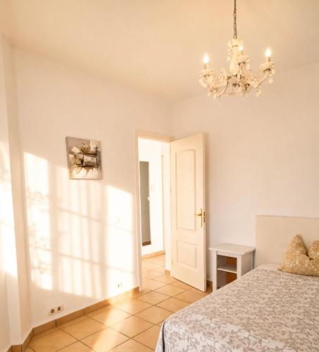 a bedroom with a bed and a chandelier at Lina Mogan in Puerto de Mogán