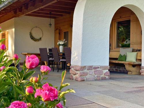 an outdoor patio with chairs and a table and flowers at Ferienhaus Eichenseer Gallzein - Alleinlage mit Garten, Wald & Bergblick in Gallzein