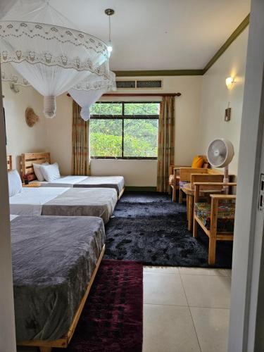 a hotel room with two beds and a window at Aivilo Home in Entebbe