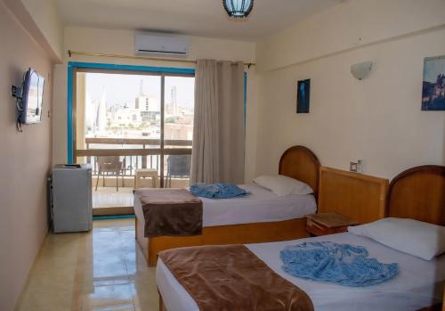 a hotel room with two beds and a window at Royal Crown Hotel Marsa Matruh in Marsa Matruh
