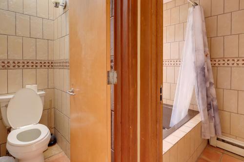 a bathroom with a toilet and a bath tub at Golf, Lakes & Trails! Truth Or Consequences Home in Truth or Consequences