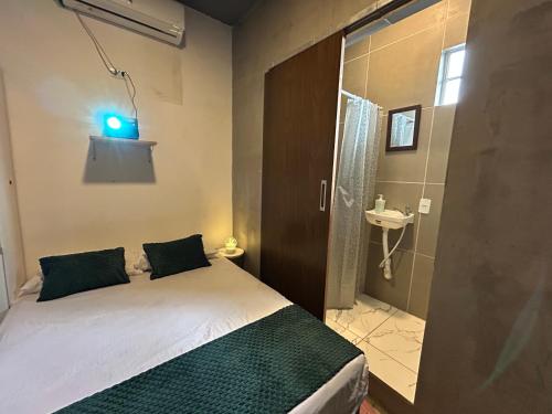 a small bedroom with a bed and a bathroom at Suíte Neblina in Garanhuns