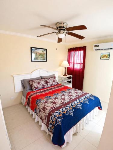 a bedroom with a bed and a ceiling fan at Kenridge Residences in Saint James