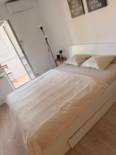 ein Bett in einem weißen Zimmer mit einem Fenster in der Unterkunft Studio Enemia in Lesce