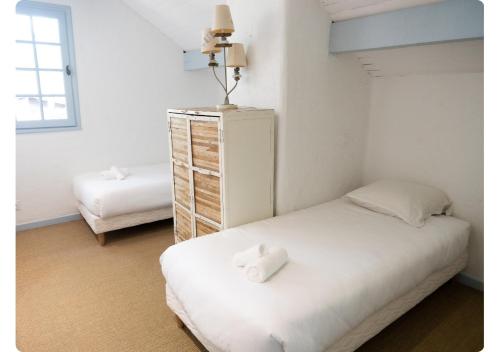 a bedroom with a bed and a dresser with two towels at Maison de Charme,Plage et Forêt, 6 personnes in Seignosse