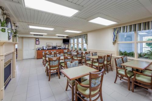a dining room with tables and chairs and windows at The Inn at Apple Valley, an Ascend Collection Hotel in Pigeon Forge