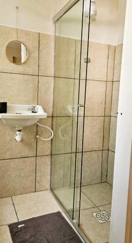 a bathroom with a shower and a sink at Tribus Hostel in Manaus