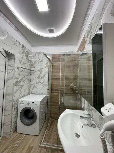 a bathroom with a washing machine and a sink at Guest House Nuhellari 2 in Çorovodë