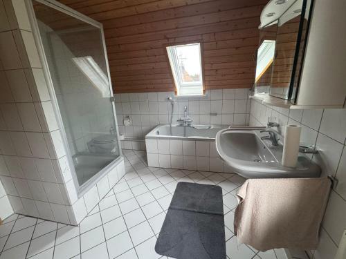 a bathroom with a sink and a shower and a tub at Ruhiges und gemütliches Appartment mit Garten in Herford