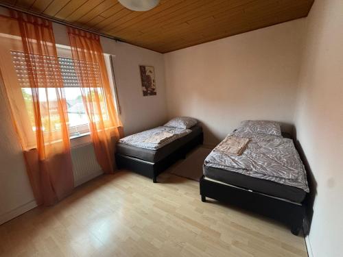 two beds in a small room with a window at Ruhiges und gemütliches Appartment mit Garten in Herford