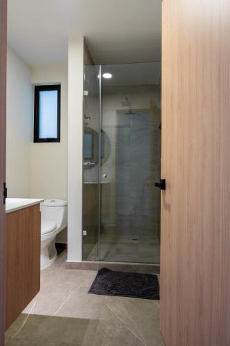 a bathroom with a glass shower and a toilet at Un escape moderno dentro de Zibatá in San Vicente Ferrer